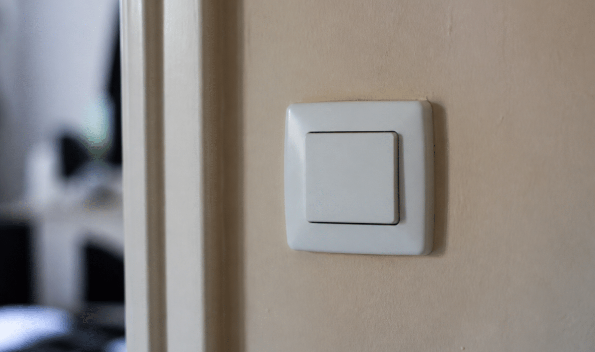 Interrupteur electrique blanc monte sur mur beige