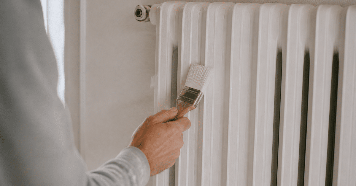 Radiateur blanc vertical recouvert de peinture avec pinceau applique