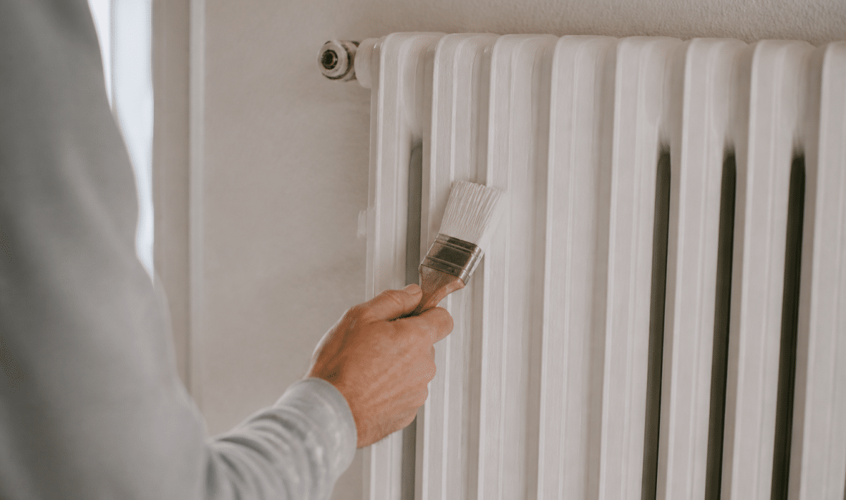 Radiateur blanc vertical recouvert de peinture avec pinceau applique