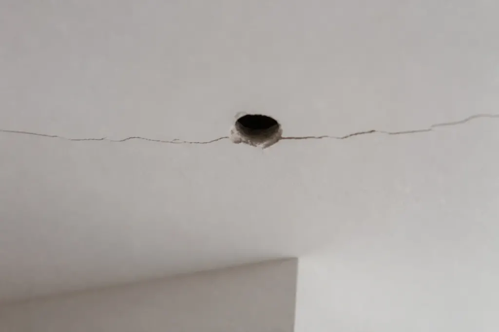 Plafond fissure pres dun trou de perceuse mal aligne