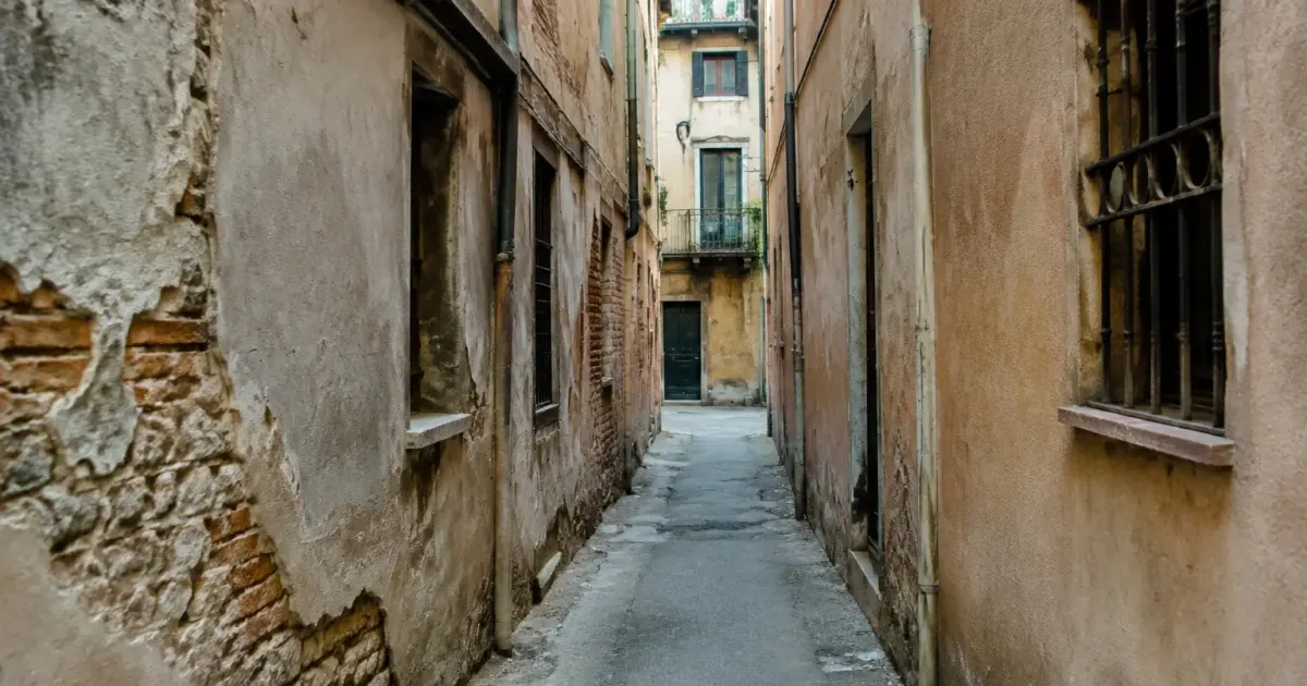 Ruelle urbaine etroite flanquee de batiments delabres et nus
